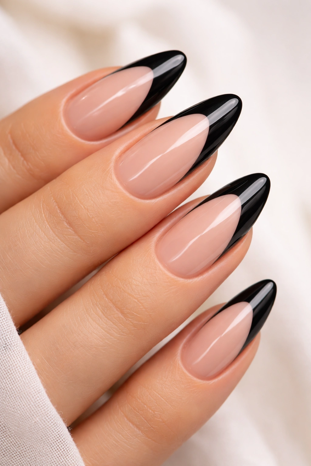 Close-up of almond nail with black tip and nude negative space