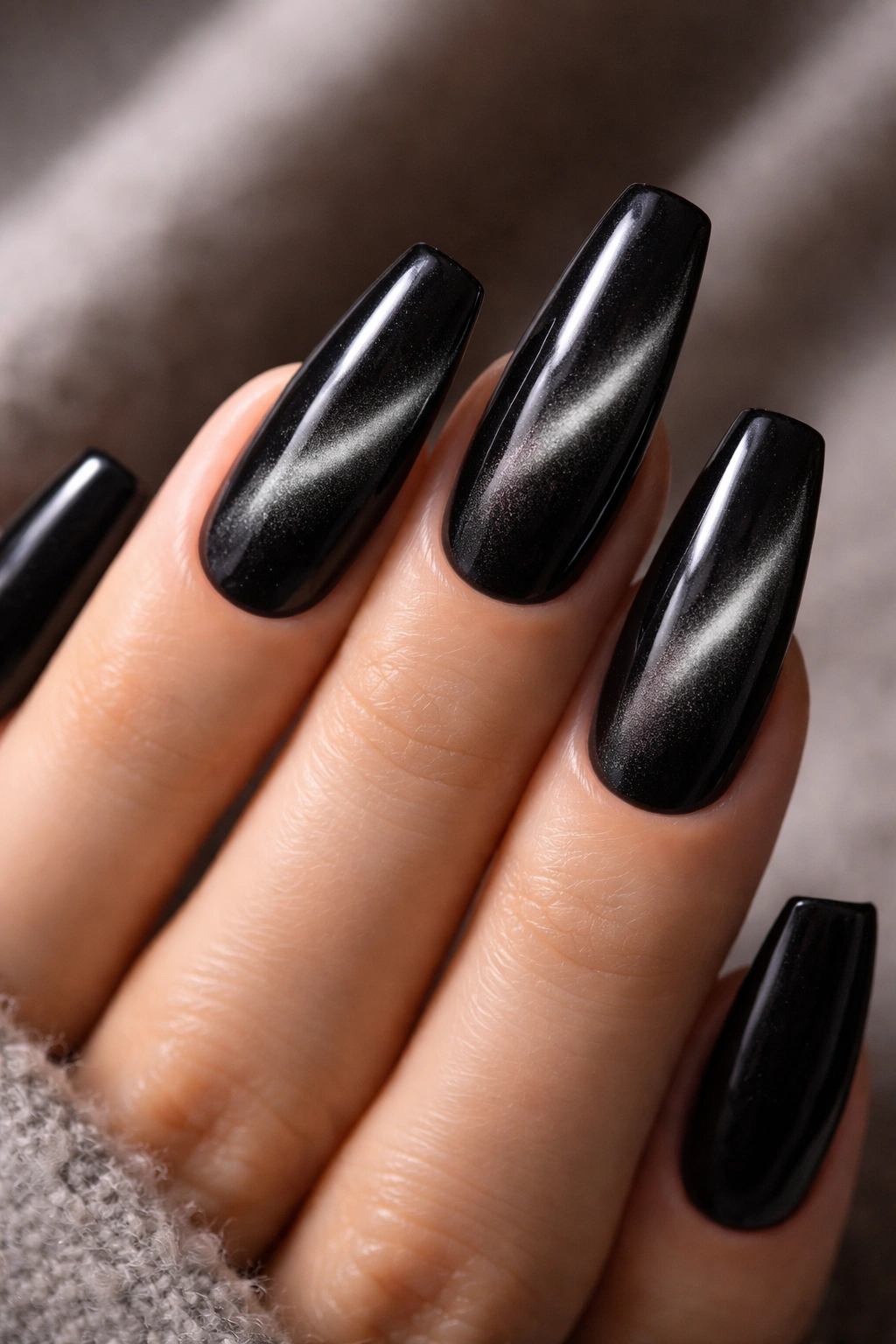Close-up of black velvet magnetic nails with a shifting light band