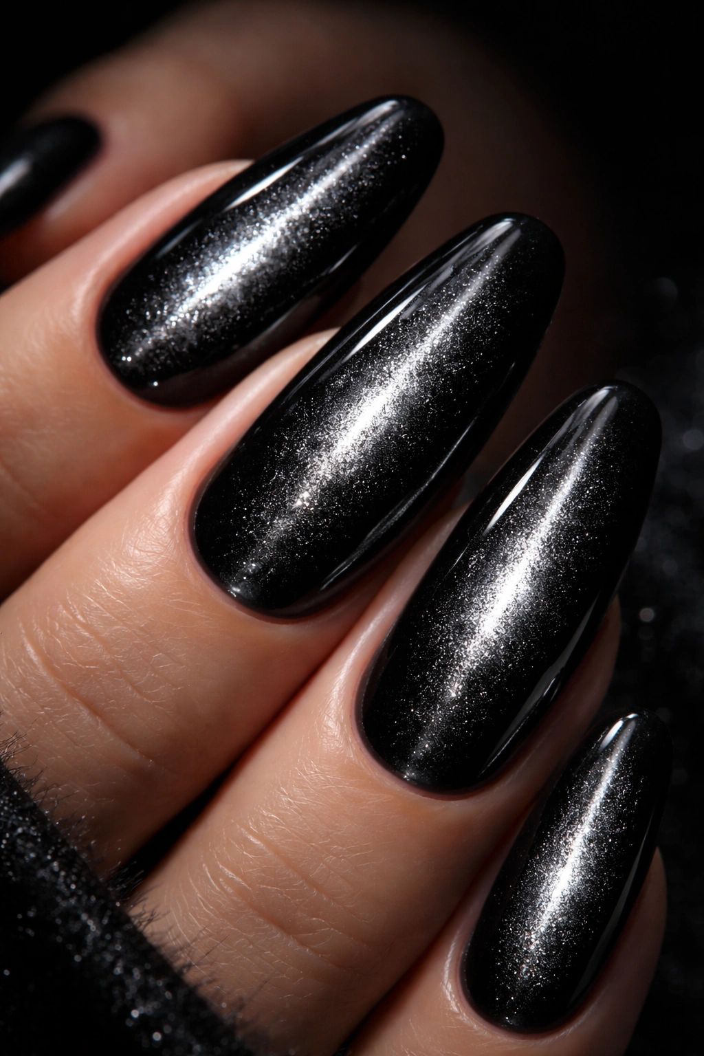 Close-up of black velvet nails with a silver centerline shimmering effect