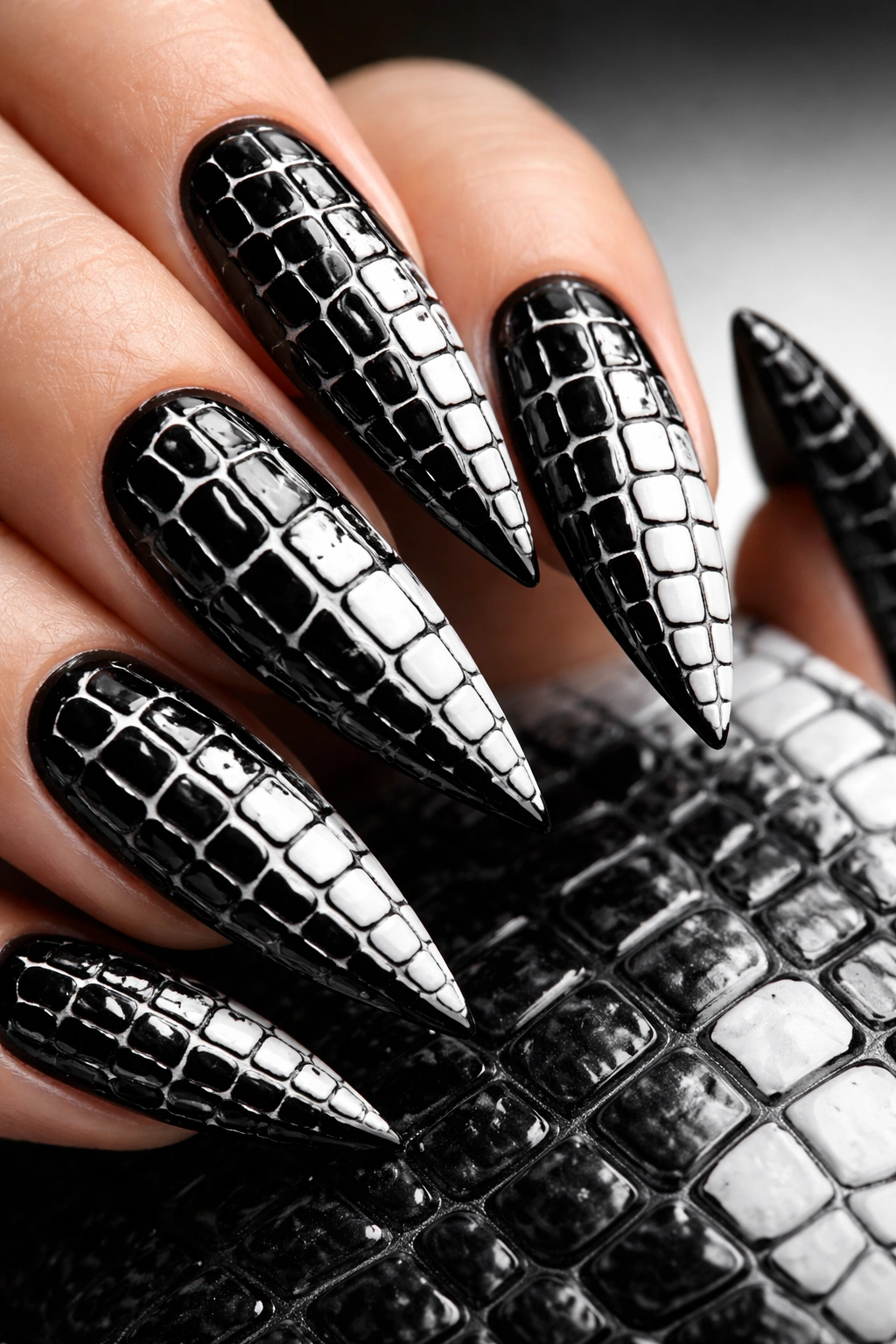 Close-up of black nails with white crocodile texture in high-contrast manicure