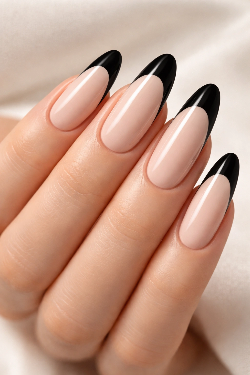 Long oval nails with nude base and black tip French manicure