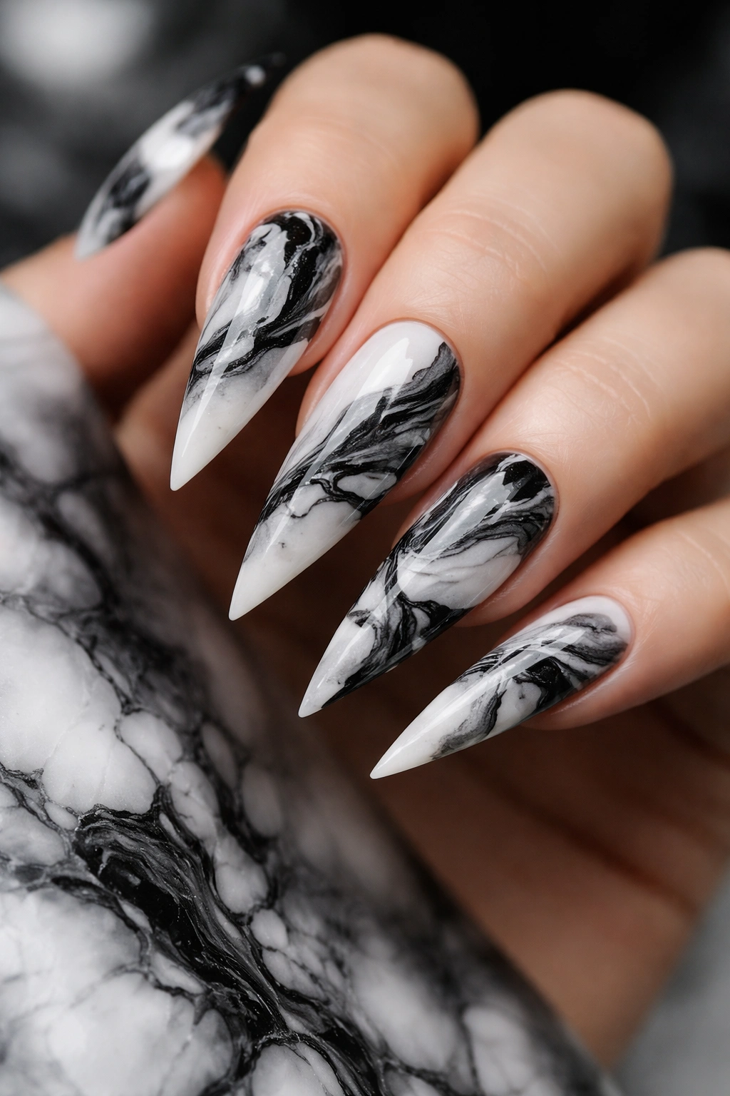 Close-up of black and white marble stiletto nails