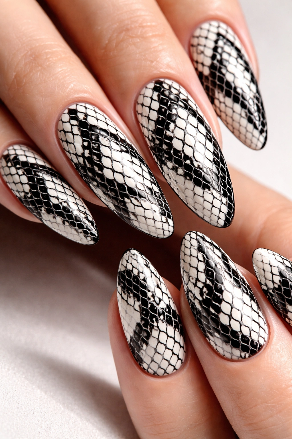 Close-up of nails with white base and black snake scale pattern.