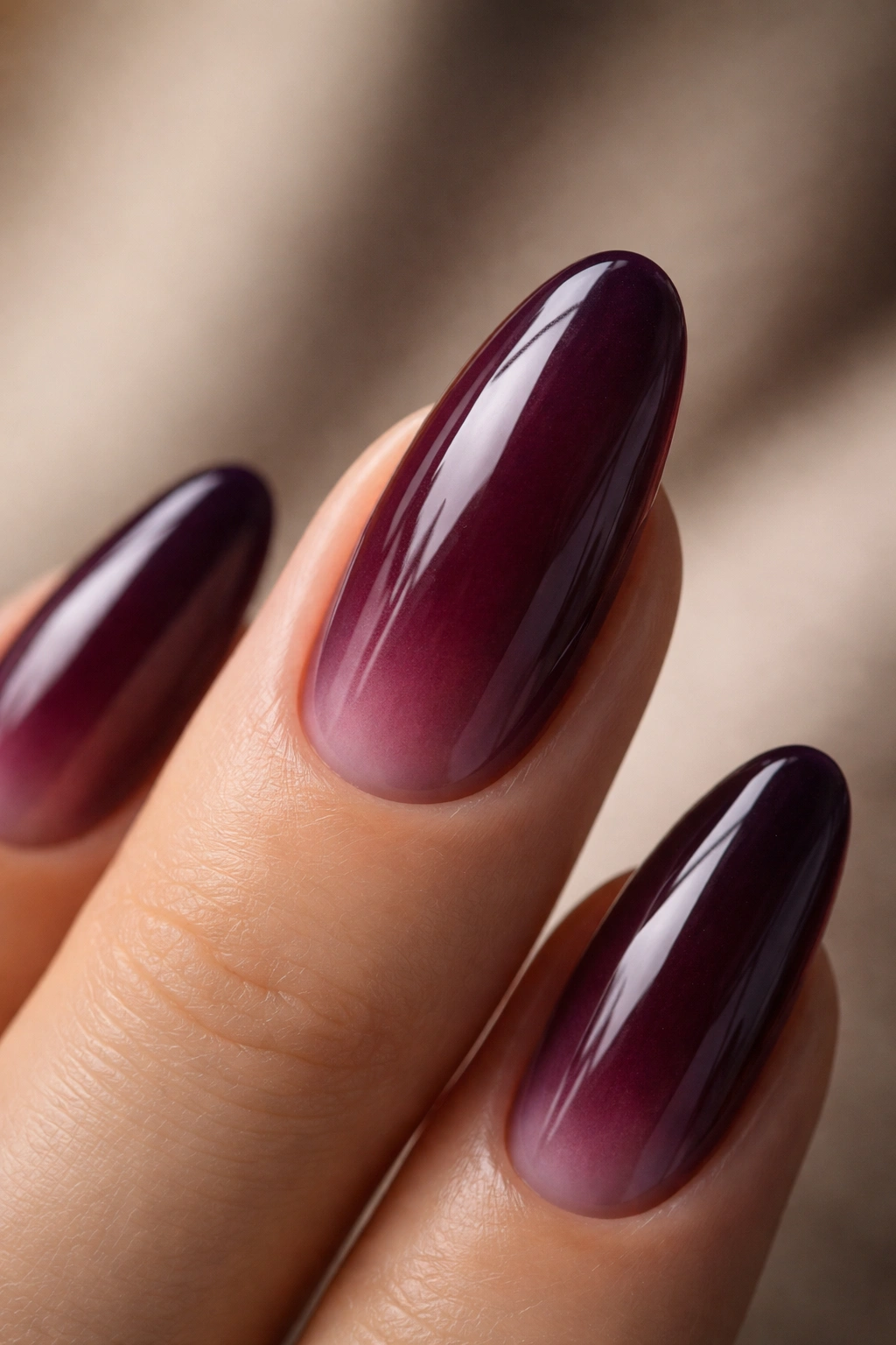 Close-up of a long oval nail with translucent blackberry jelly polish