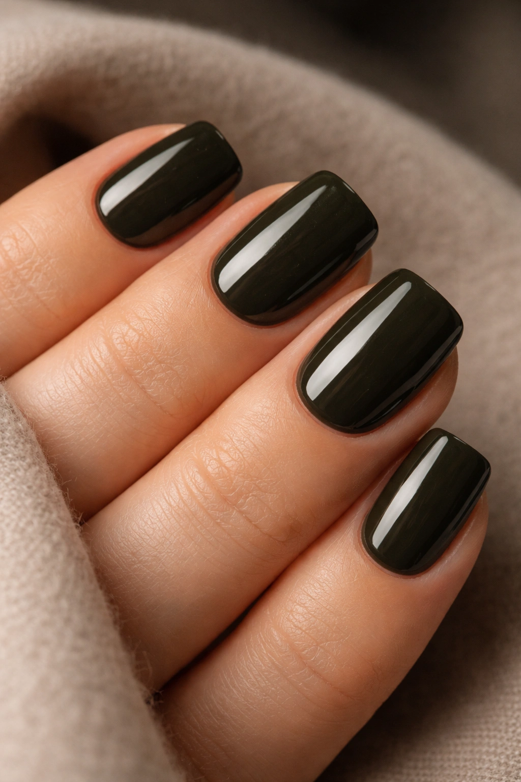 Close-up of blackened olive squoval nails with moody brown-green shade