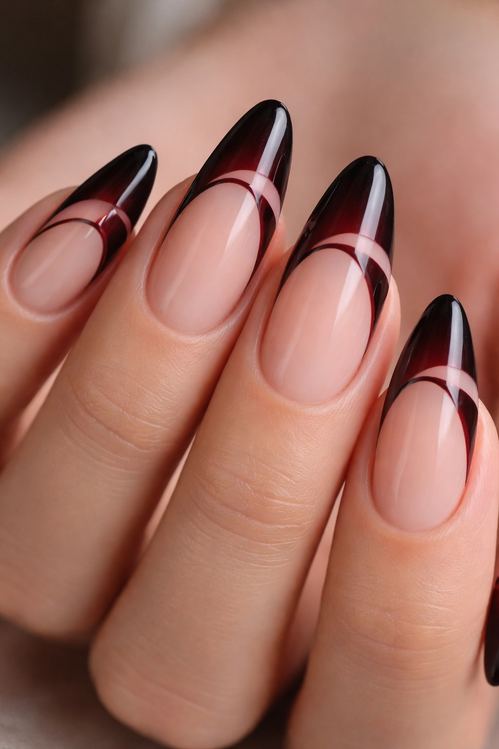 Almond nails with blackened red tips and abstract negative space