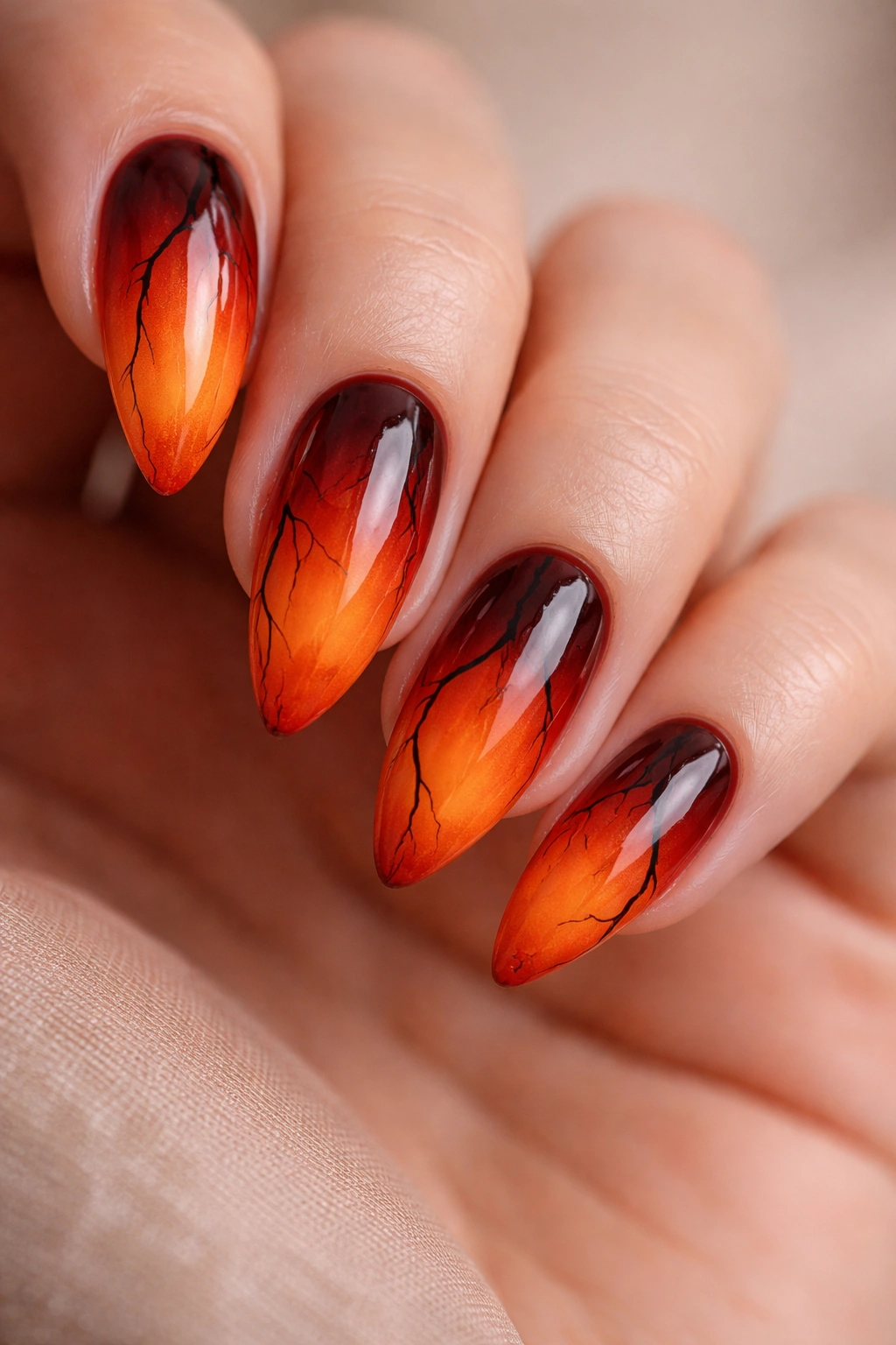 Almond nails with a blood red to orange ombre and black vein details for a Halloween look