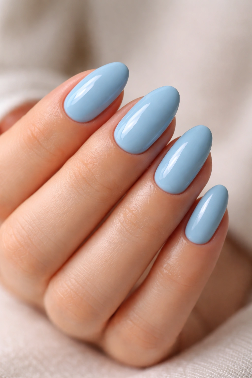 Close-up of neatly shaped short blue almond nails with clean cuticles