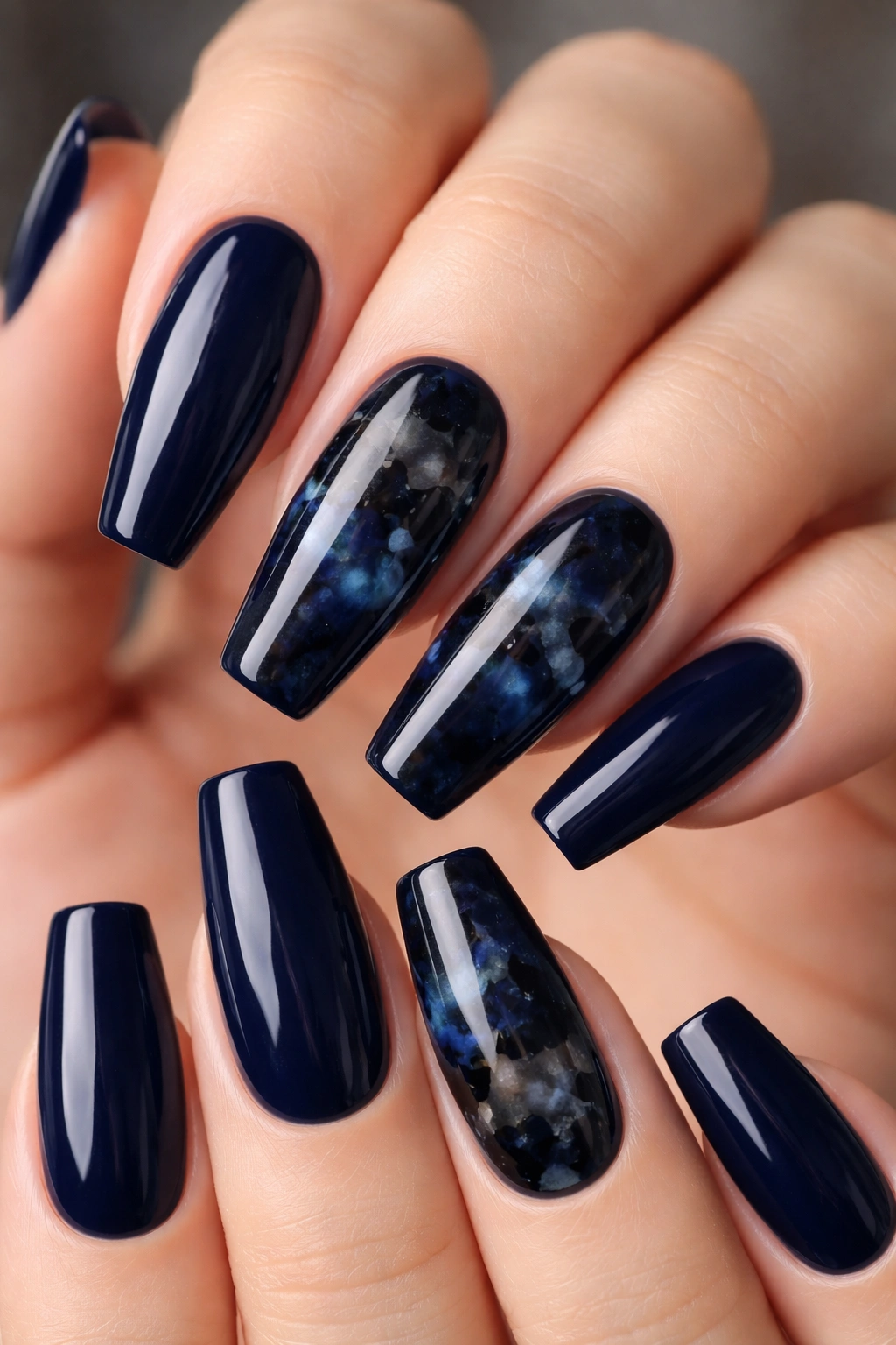 Blue-black tortoiseshell nails with sheer depth and layered patches
