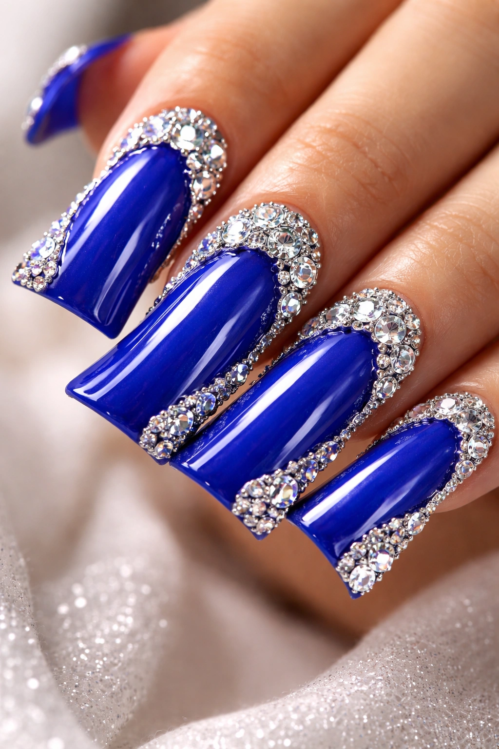Close-up of blue duck nails with rhinestone clusters sparkling on manicured nails