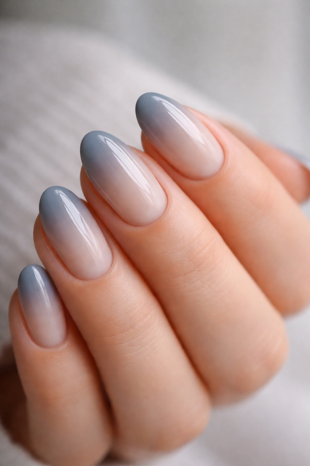 Short almond nails with smoky gray to blue ombre and glossy finish
