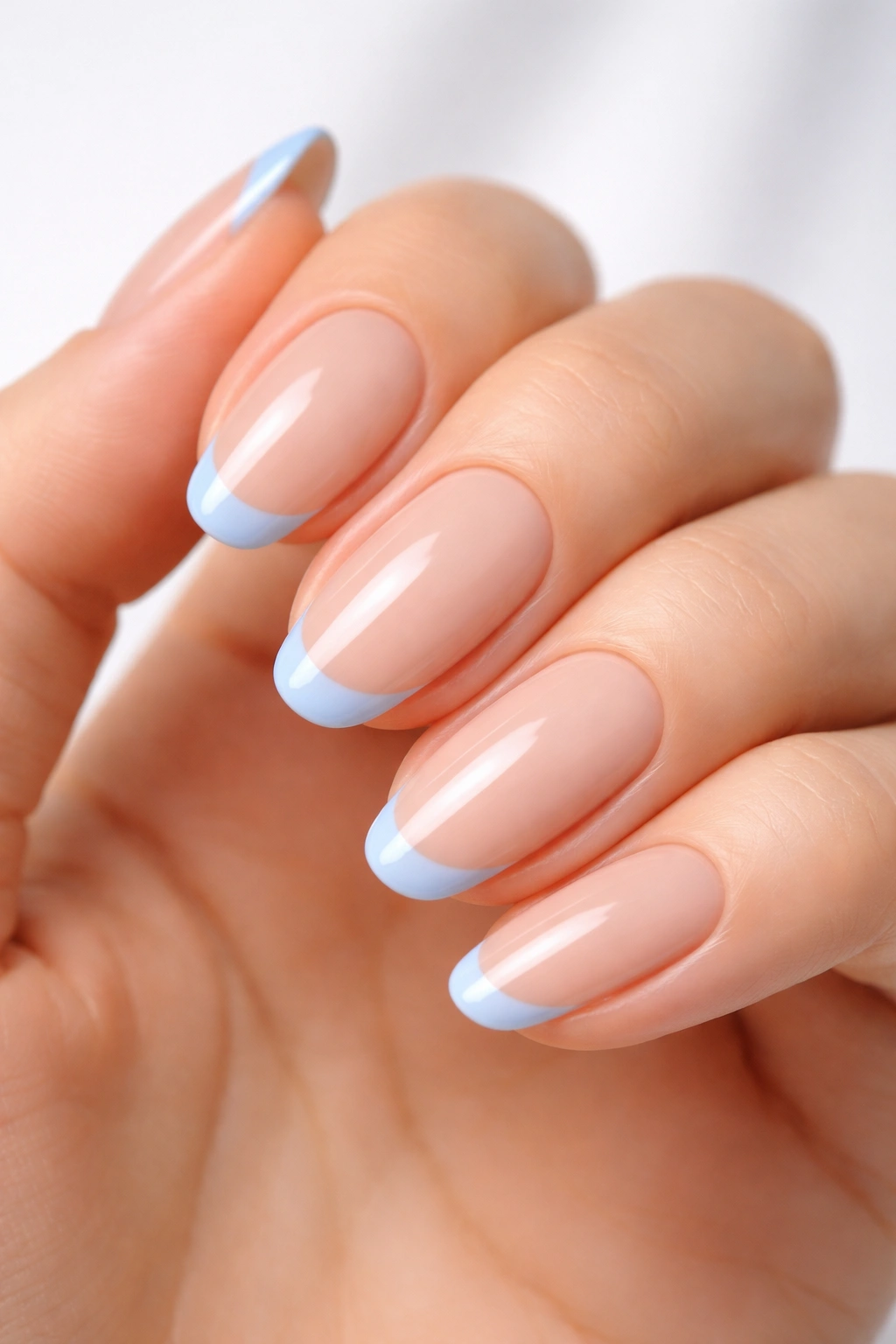 Close-up of minimalist light blue French tips on nude base