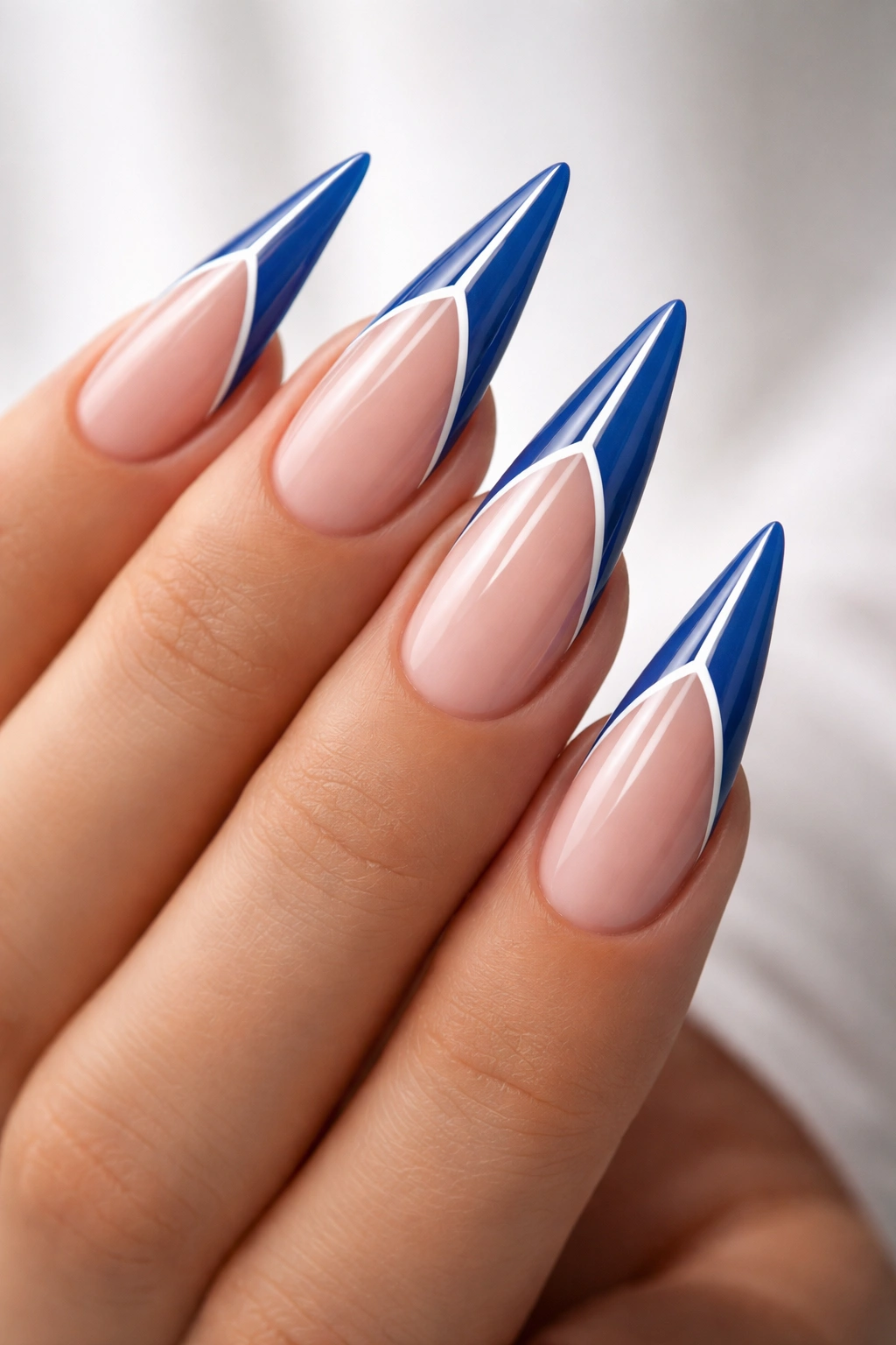 Close-up of blue French tips with a white striping line on stiletto nails