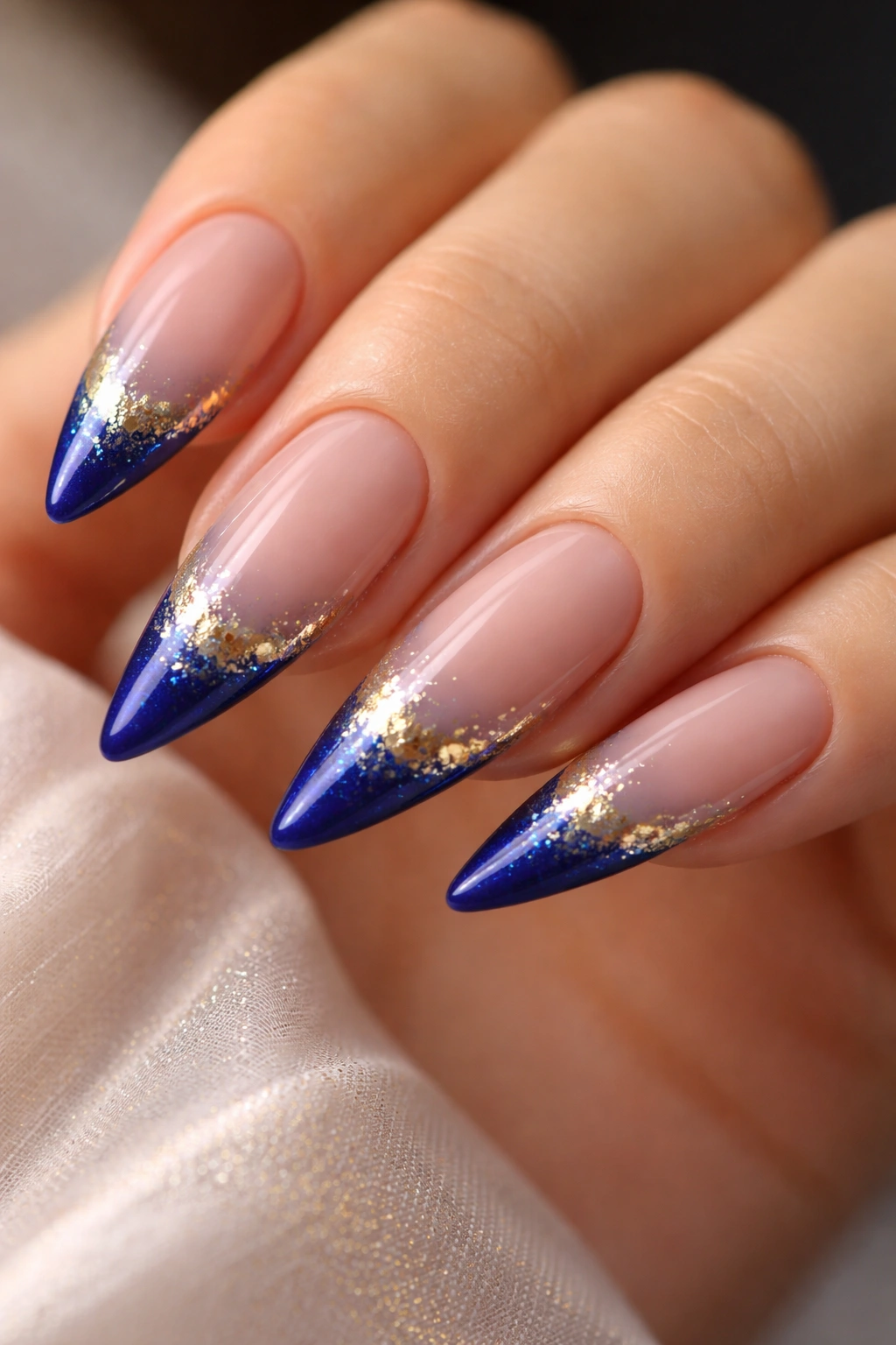 Blue nails with gradient gold foil at the tips