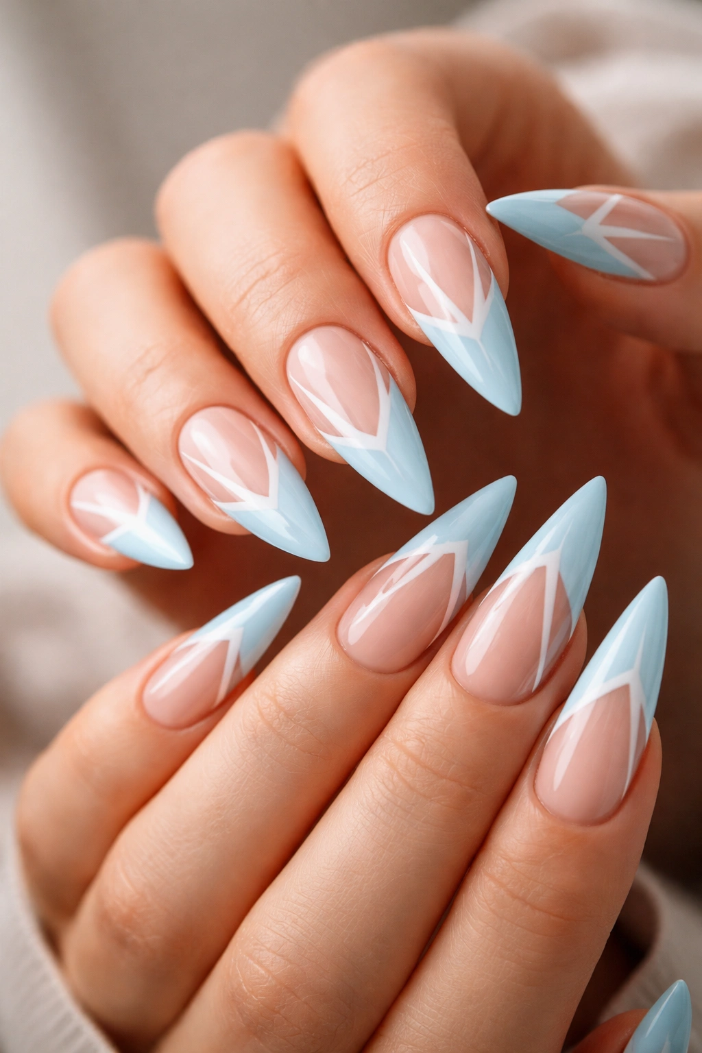 Close-up of baby blue stiletto nails with negative-space white geometric cutouts