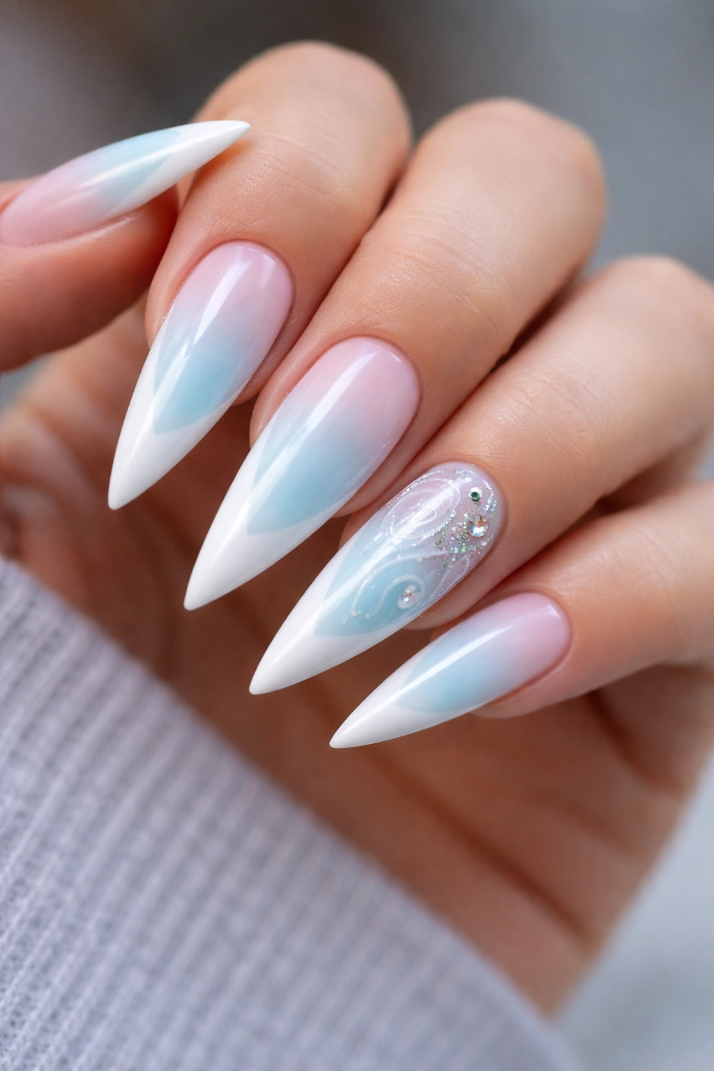Close-up of baby blue ombré nails with white tips and an accented nail
