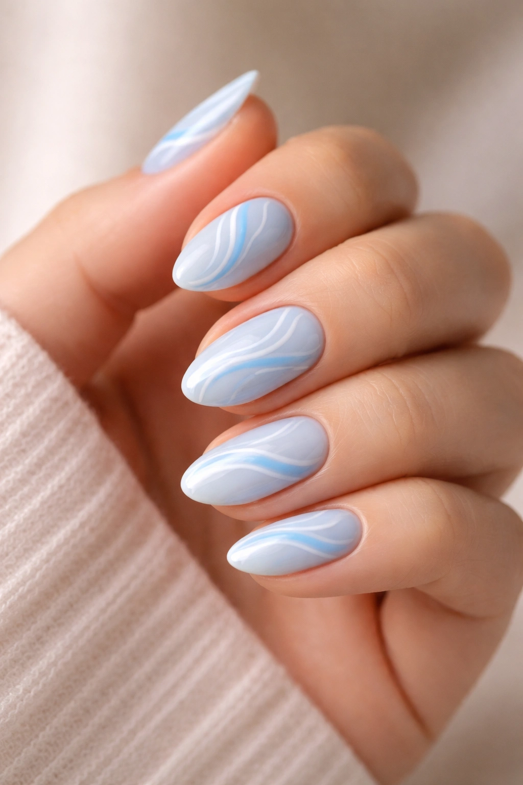 Close-up of blue swirl accent nails on pastel blue base