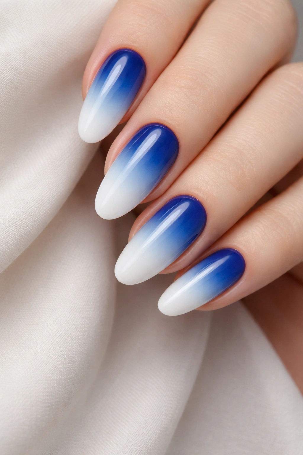 Close-up of blue to white ombre nails with smooth gradient