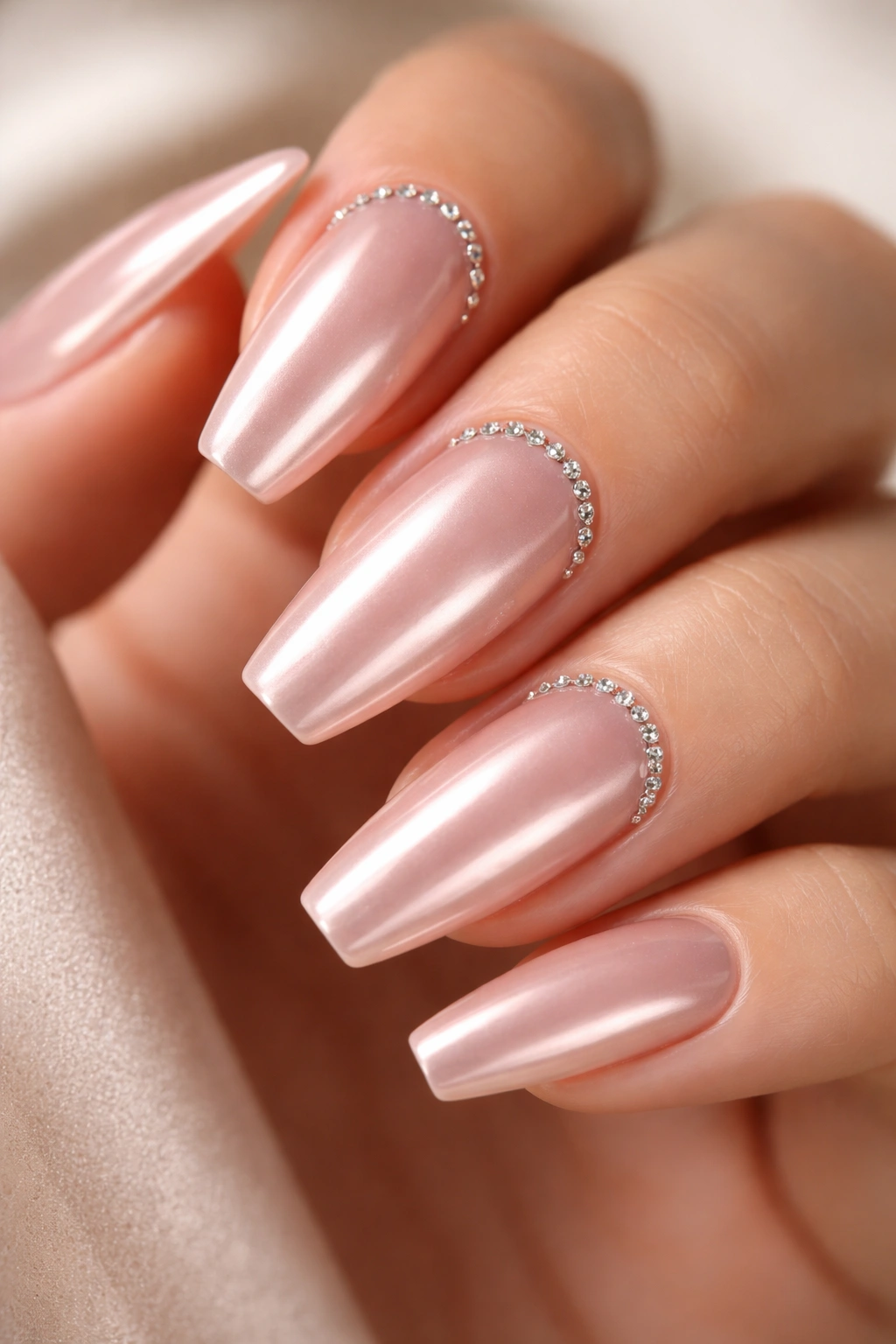 Blush chrome nails with a tiny cuticle halo of crystals