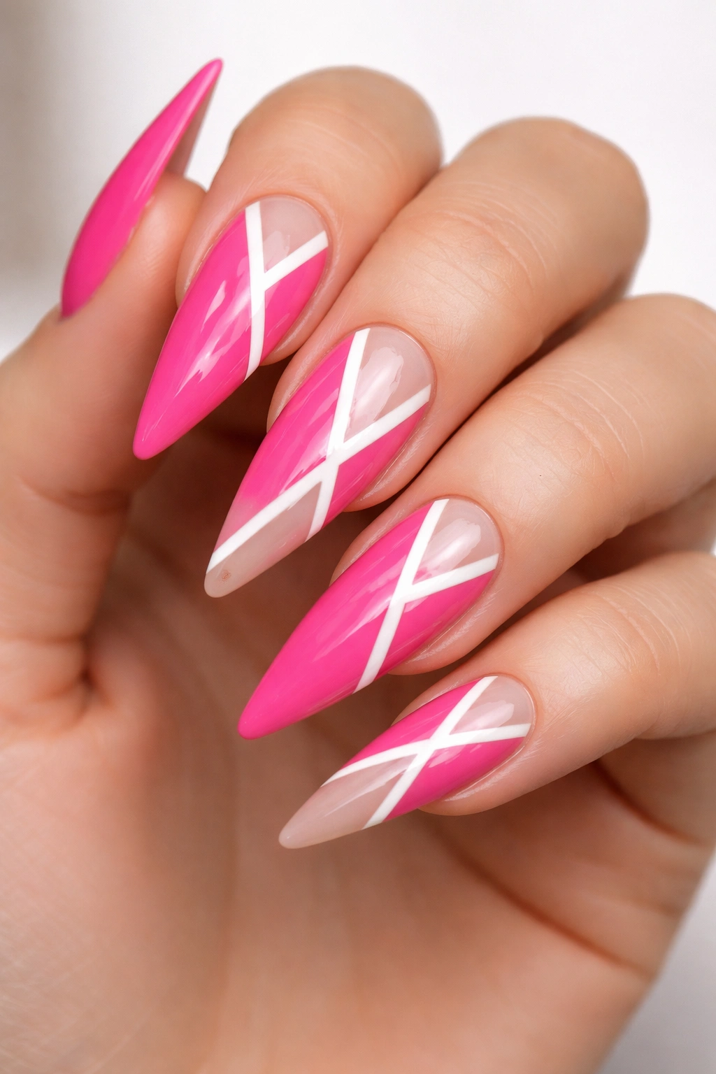 Close-up of bold pink stiletto nails showing negative-space geometric cutouts.