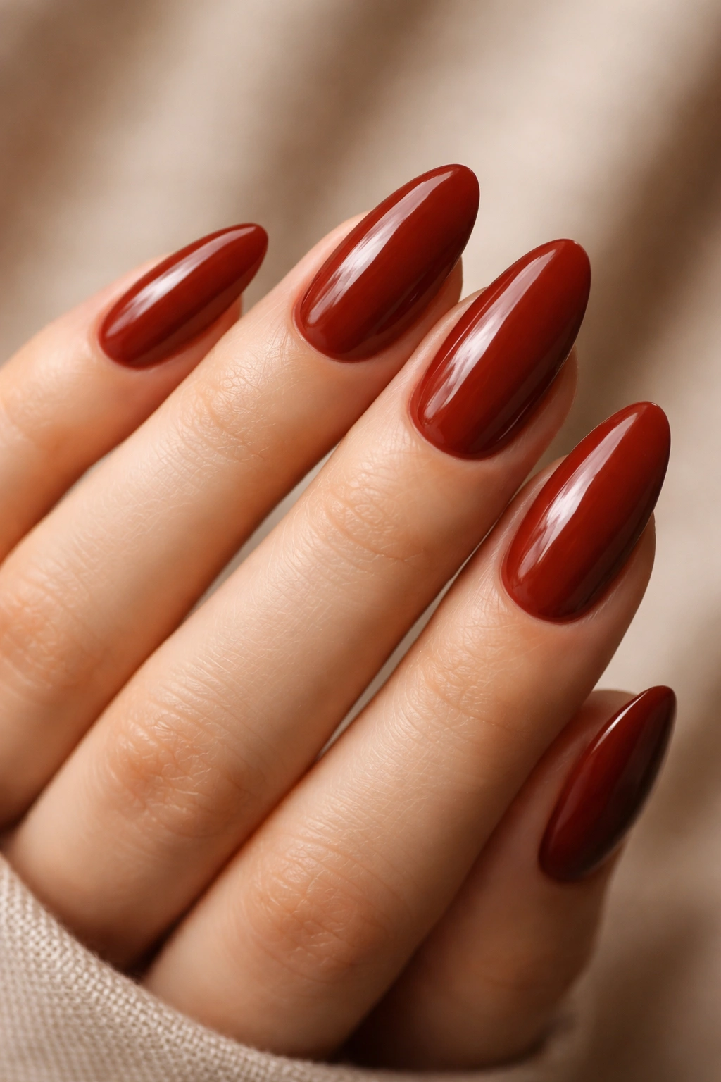 Warm brick red almond nails with glossy finish