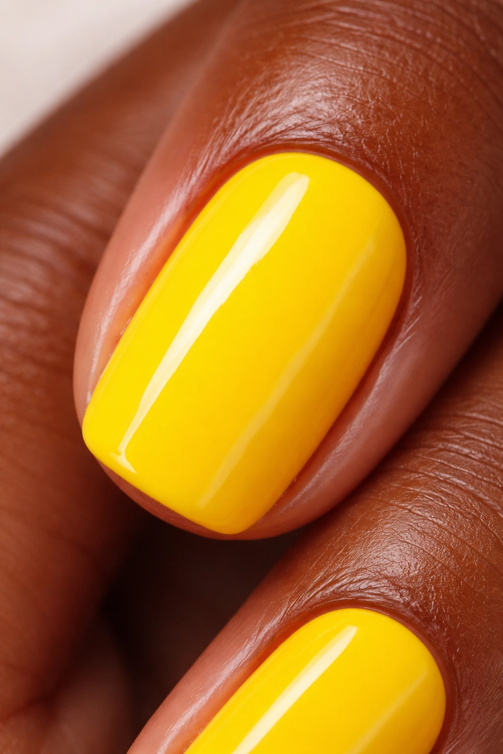 Close-up of a fingernail painted bright yellow