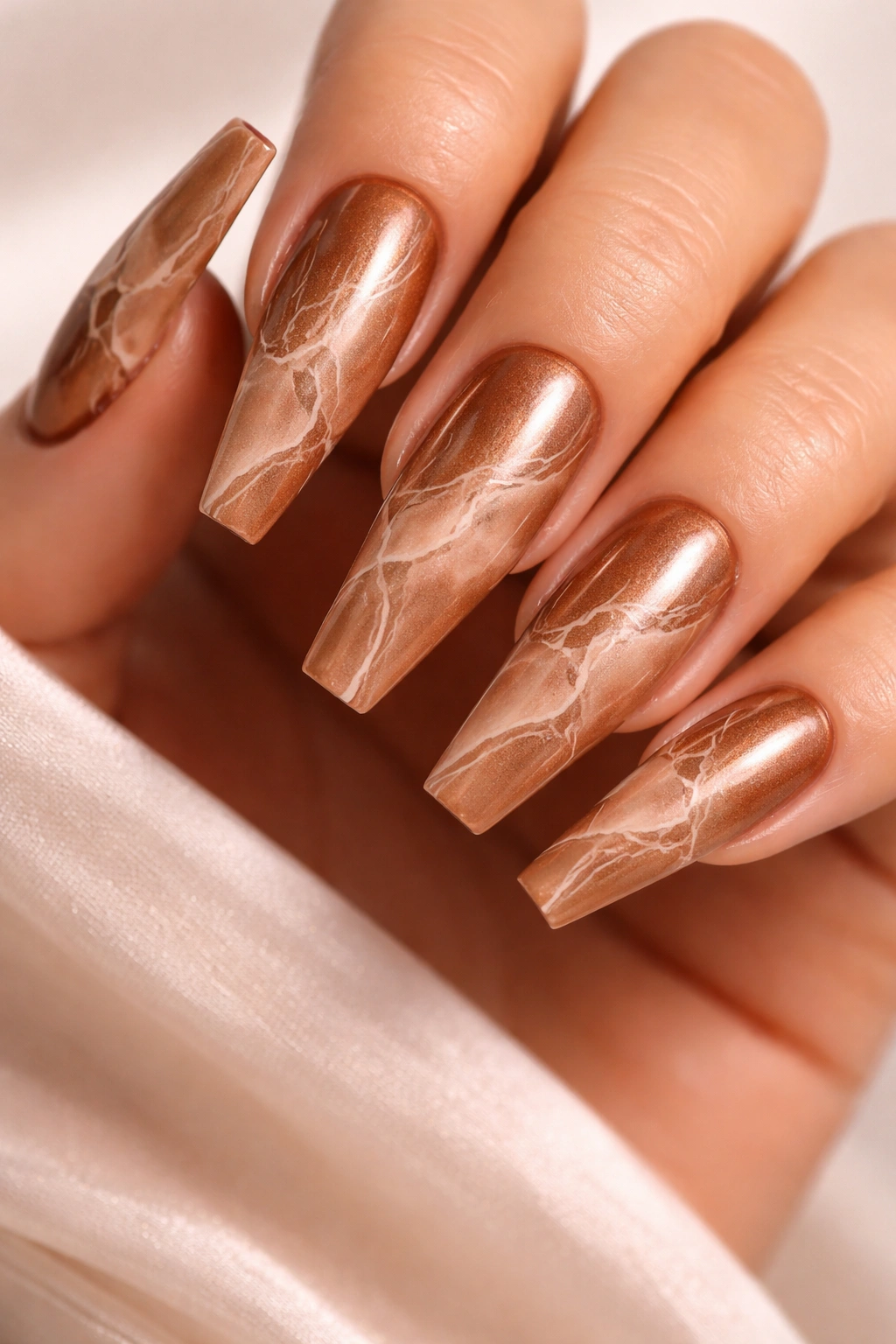 Long coffin nails with bronze base and nude marble veining.