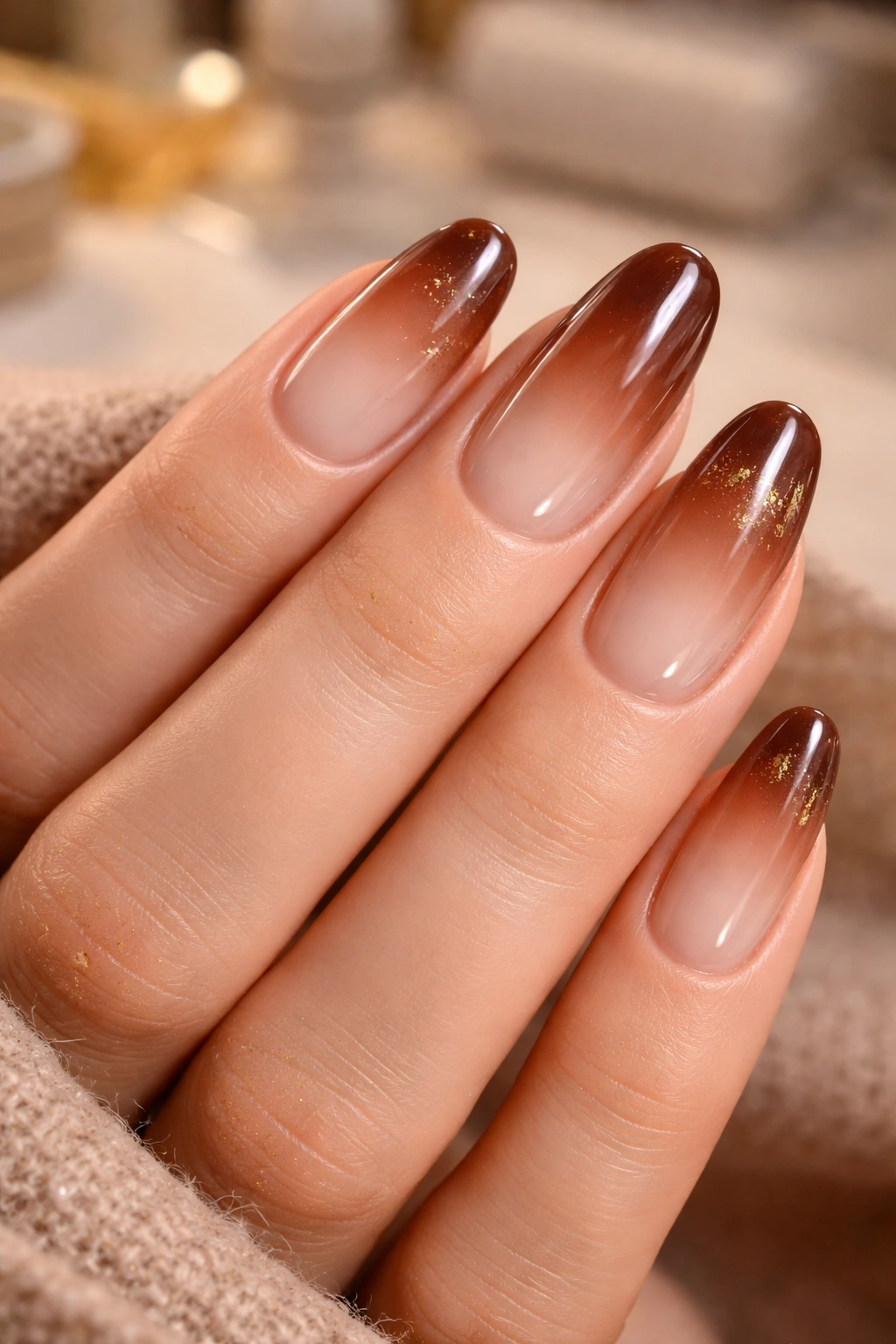 Close-up of brown aura nails with latte-to-espresso gradient and subtle gold accents near the cuticle