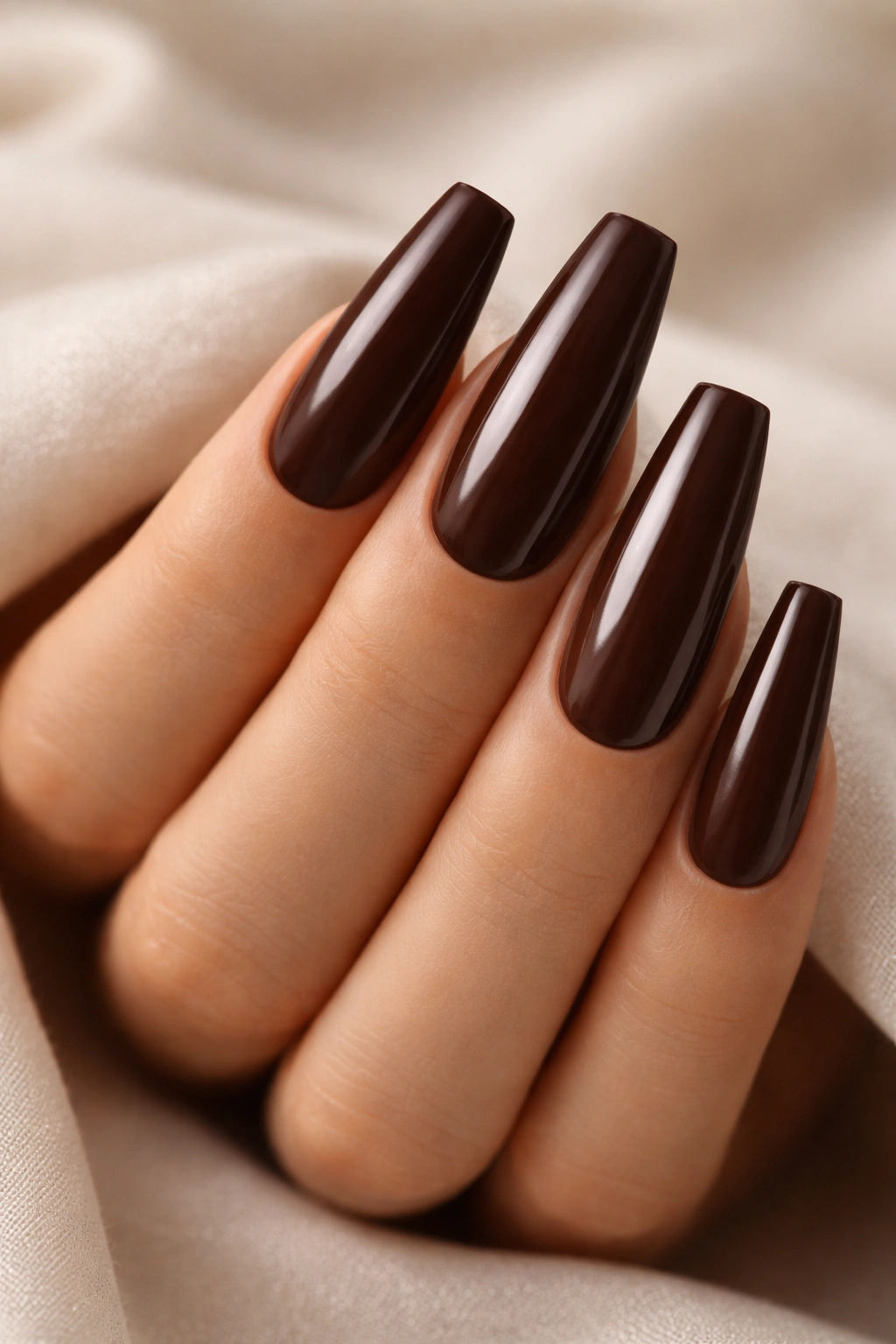 Close-up of long coffin nails painted in solid deep espresso brown satin finish