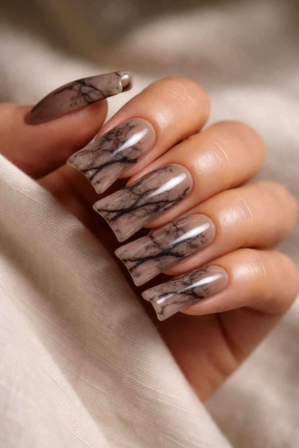 Close-up of smoky brown marble duck nails with veining