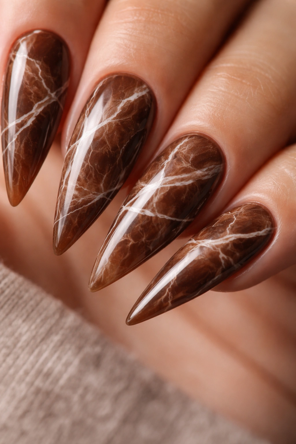 Macro close-up of brown marble nails with white veining