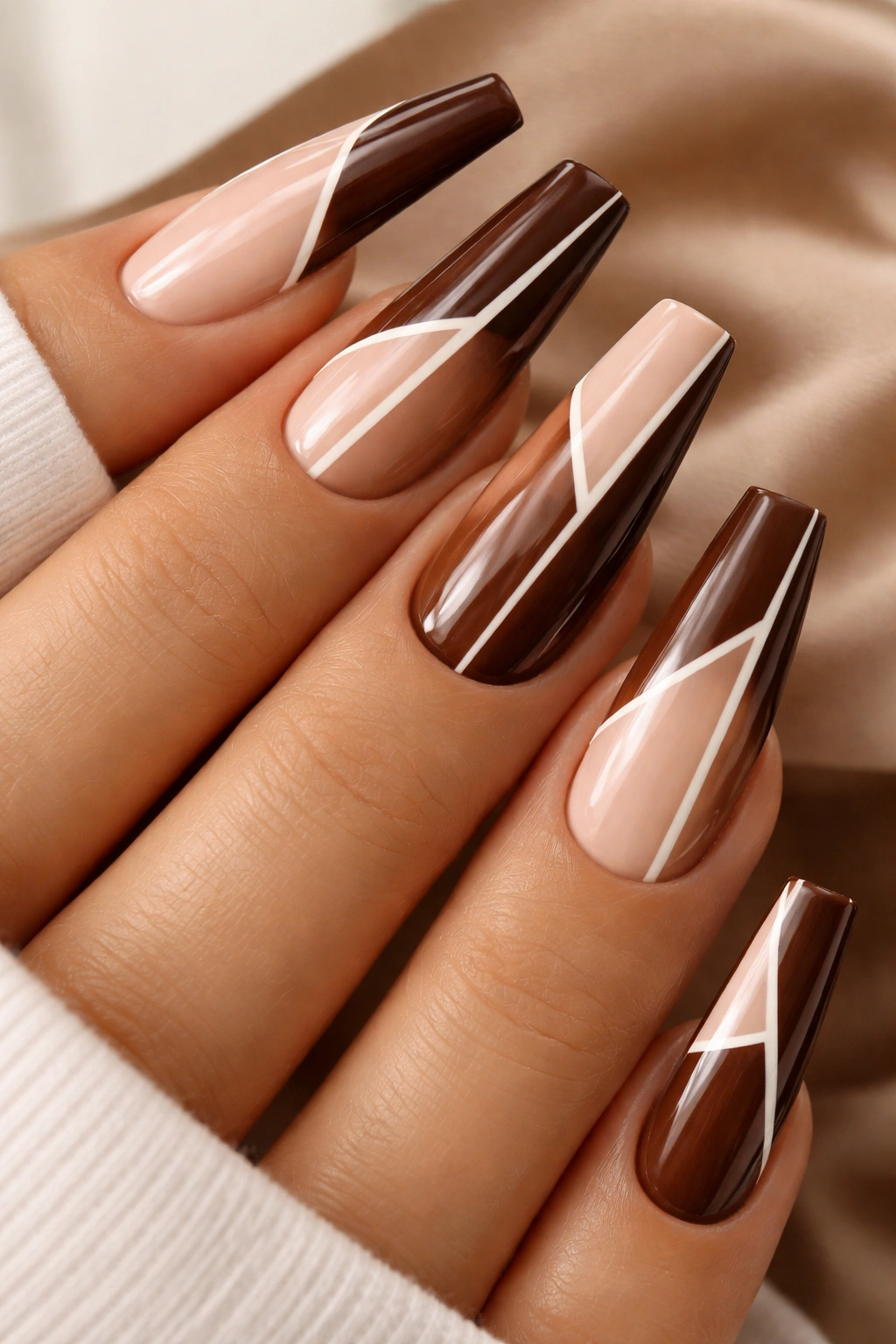 Close-up of brown nude coffin nails with geometric lines and negative space