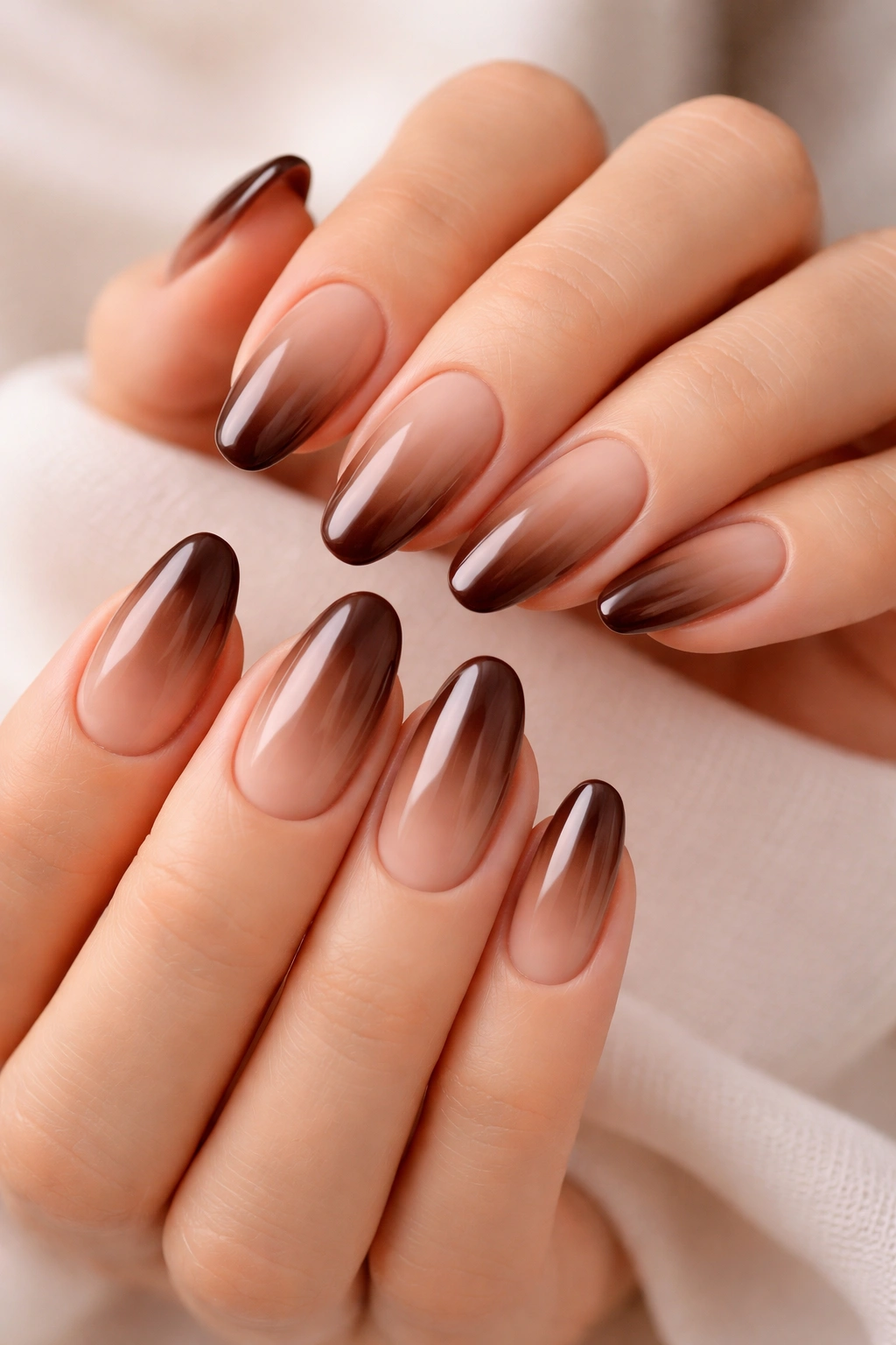 Hands with brown ombre nails in a thoughtful pose