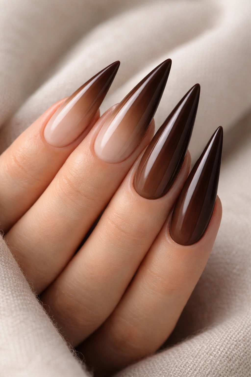 Ombre brown stiletto nails transitioning from light nude to dark chocolate