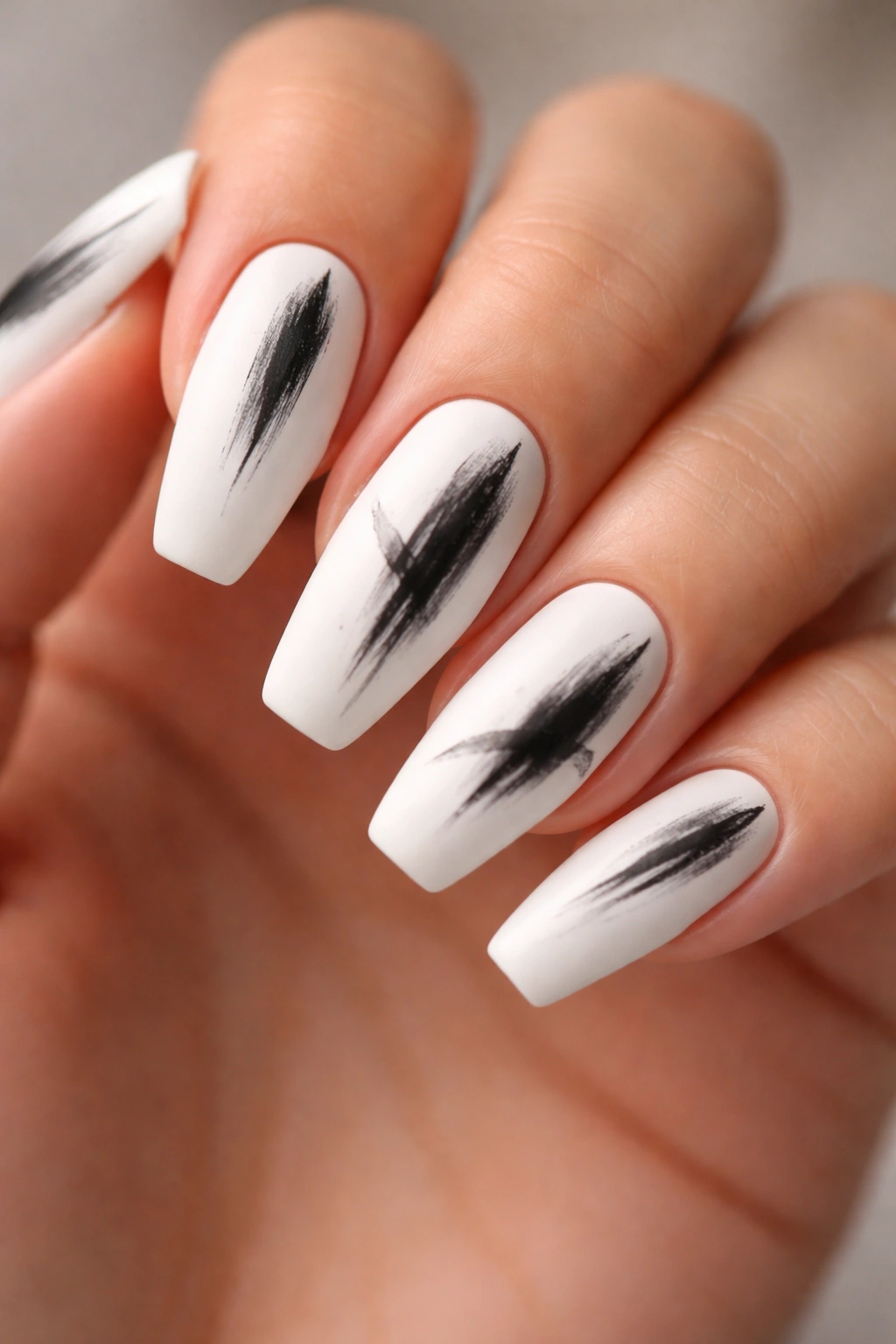 Matte white nails with loose black brushstrokes