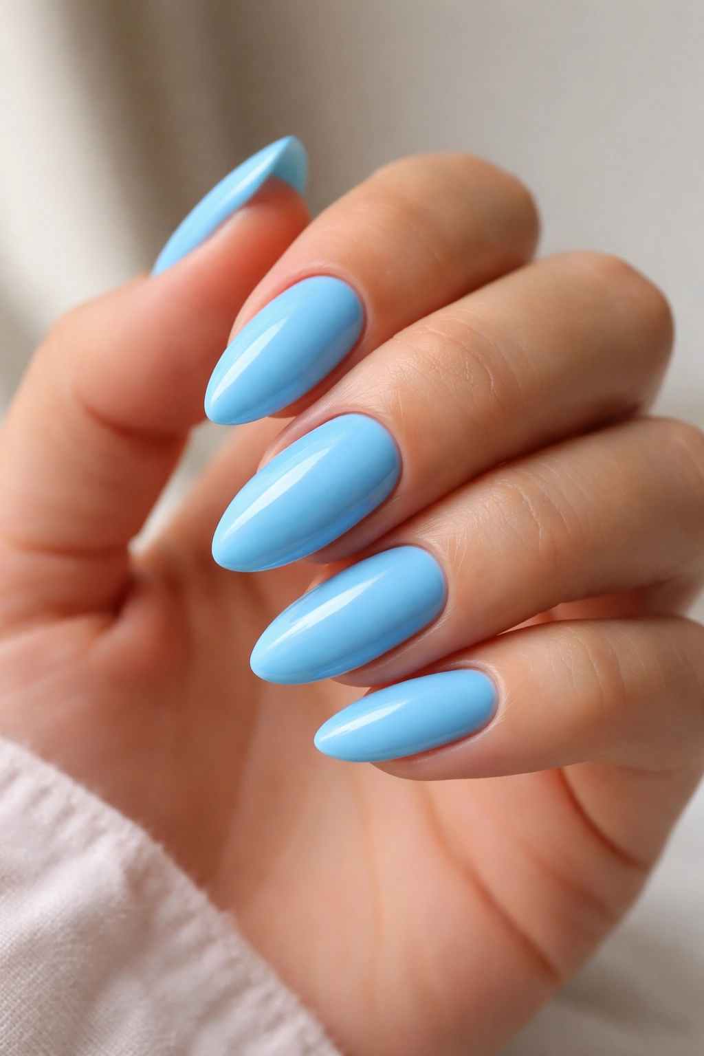 Close-up of bubblegum blue almond nails with glossy finish