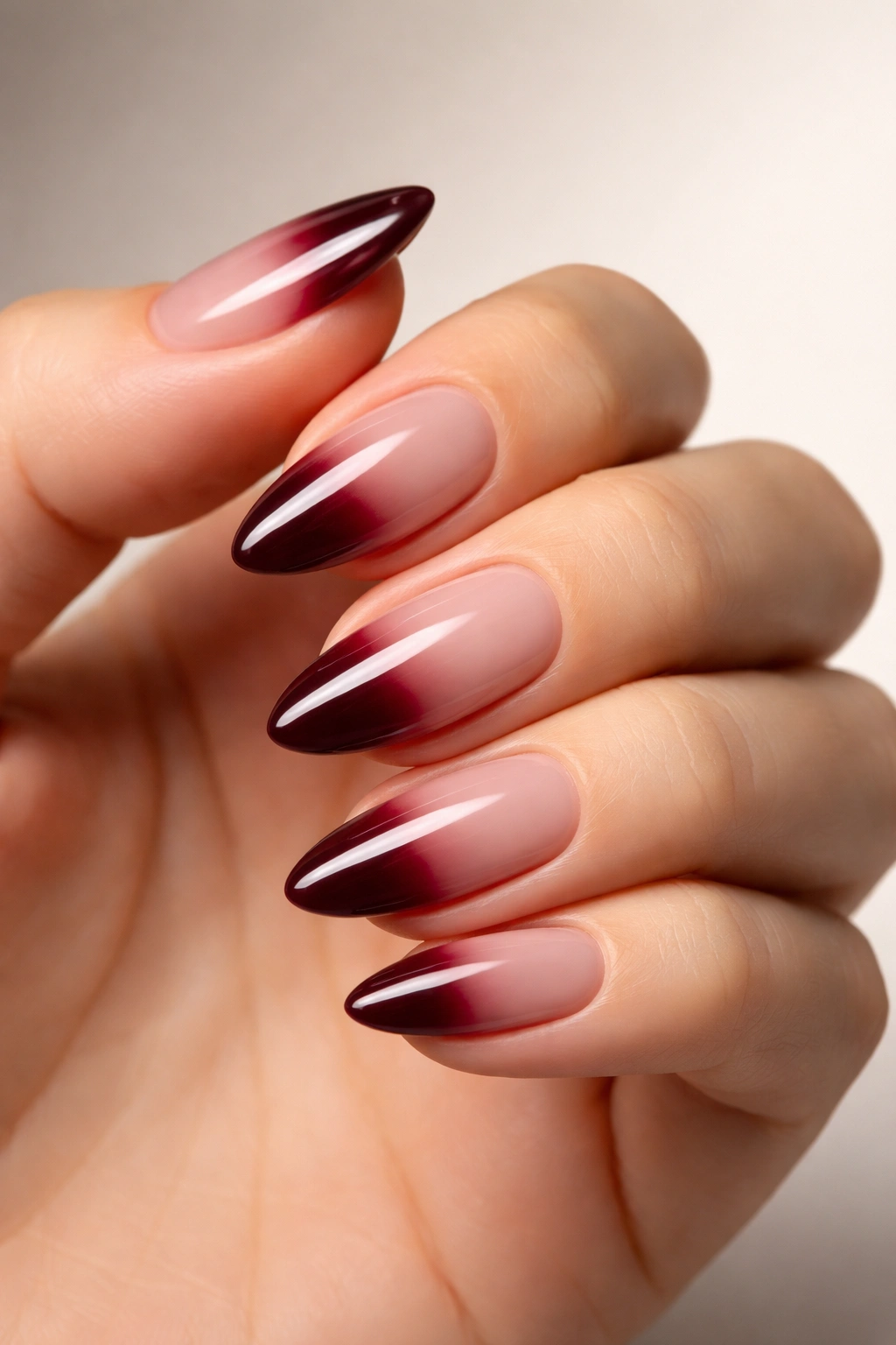 Deep burgundy almond nails with glossy finish
