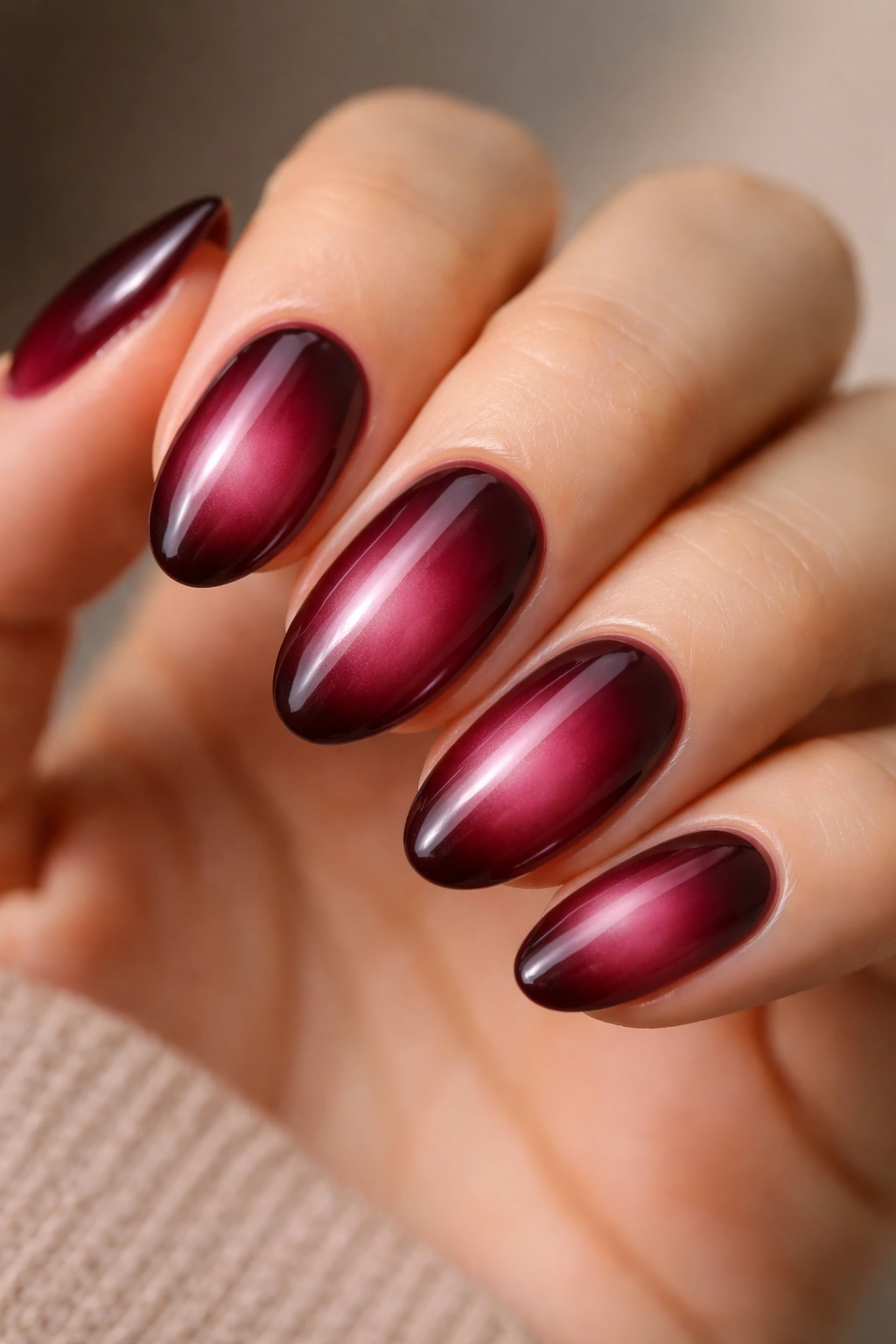 Moody burgundy aura nails on short almond nails with center glow