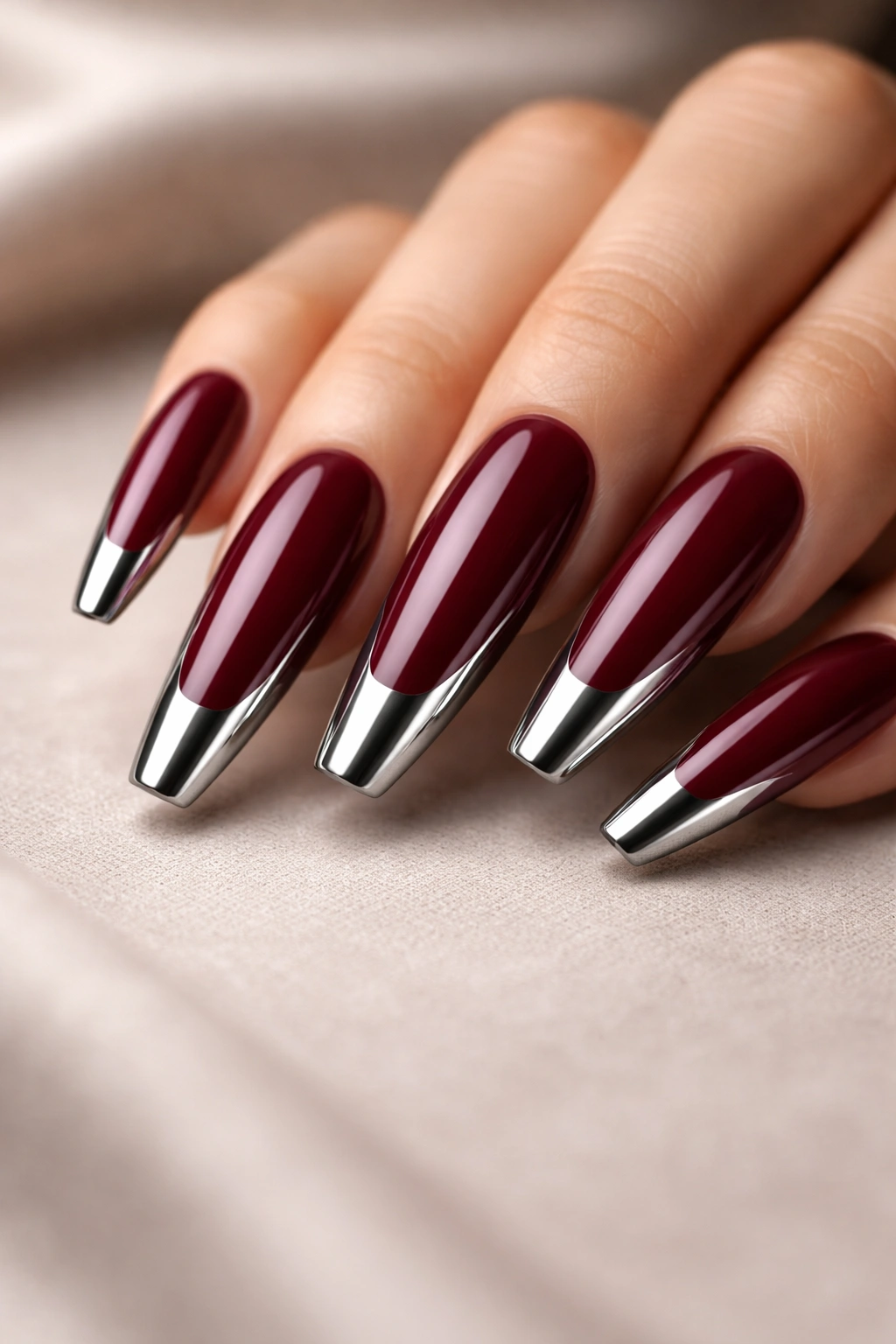 Close-up of burgundy coffin nails with chrome tips