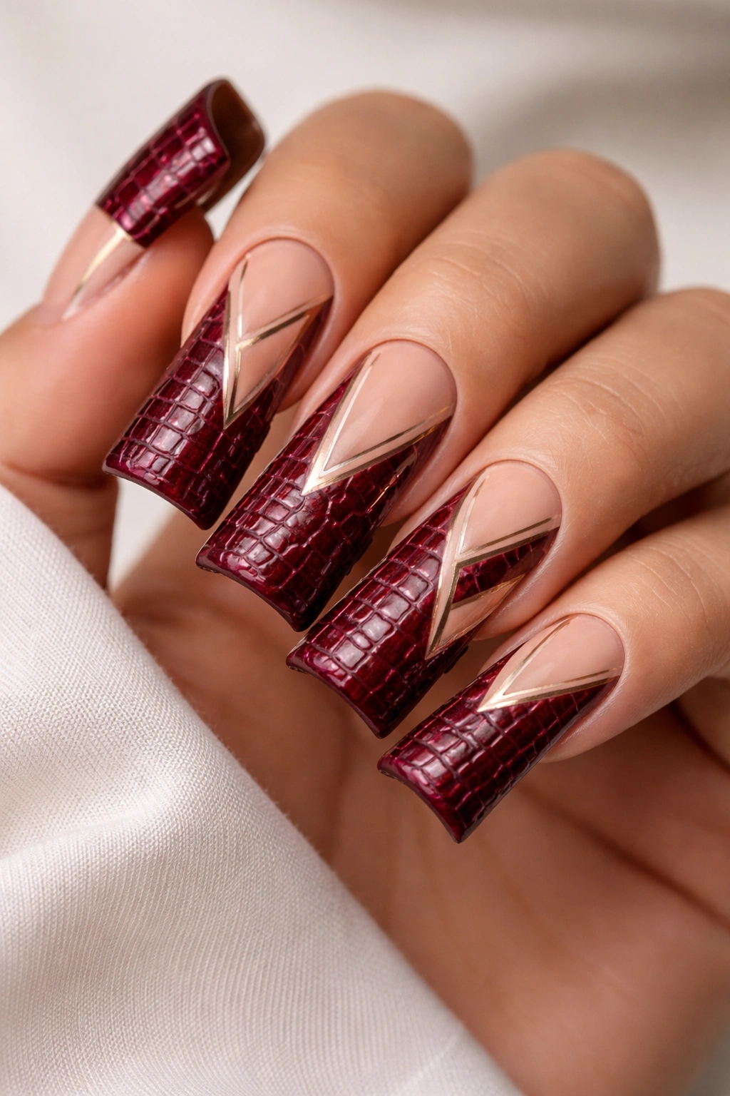 Burgundy croc nails with geometric negative-space accents