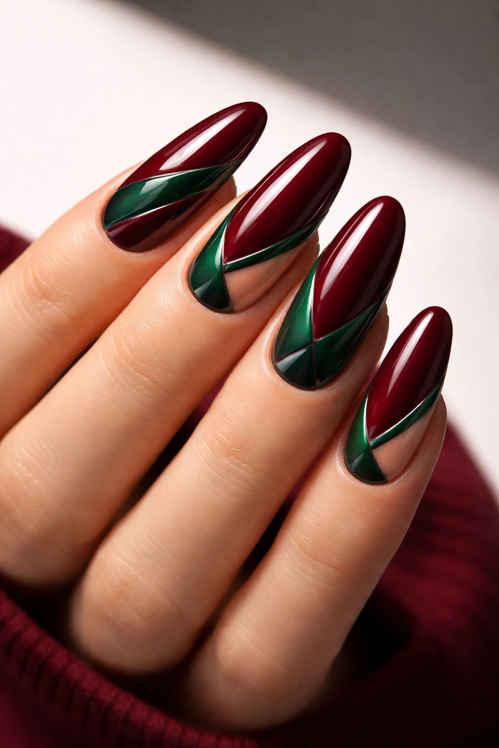 Nails with burgundy base and emerald negative-space shapes