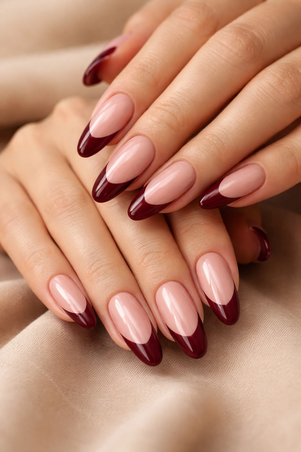 Close-up of burgundy French tip nails on nude base