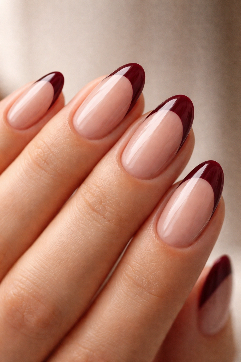 Short almond nails with burgundy French tips on nude base