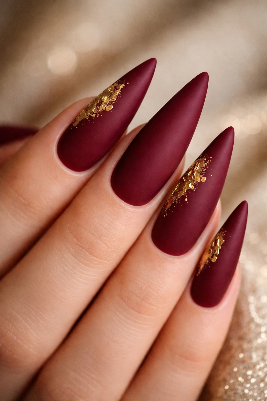 Burgundy matte nails with gold leaf accents