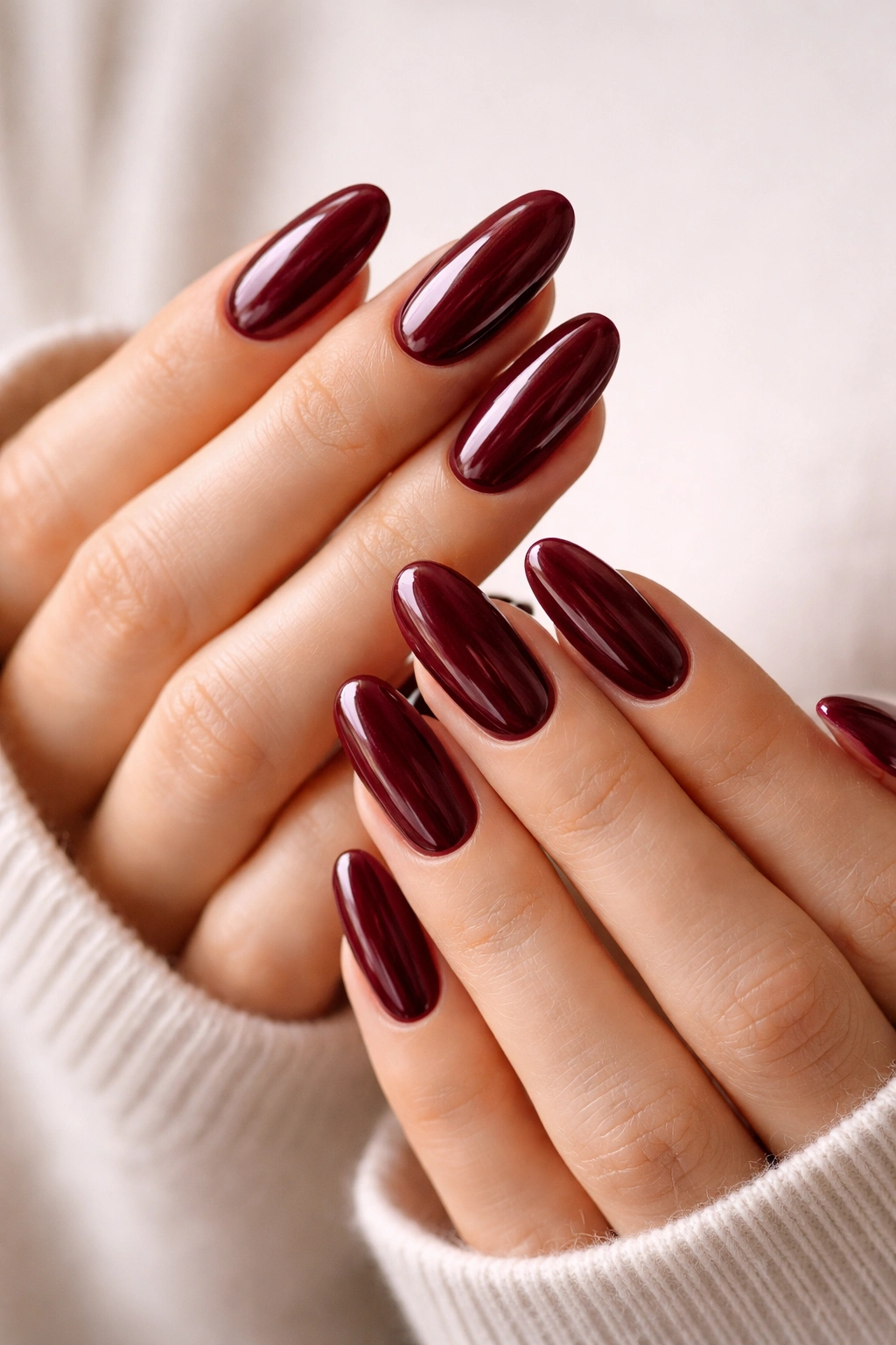Close-up of pristine burgundy long oval nails with clean edges