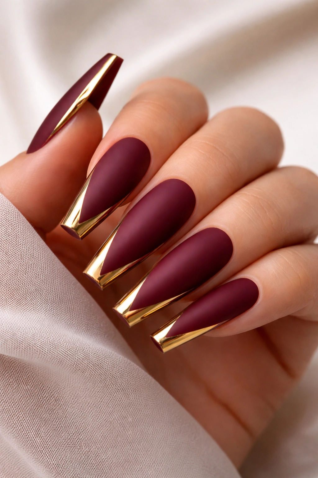 Matte burgundy coffin nails with glossy gold accents