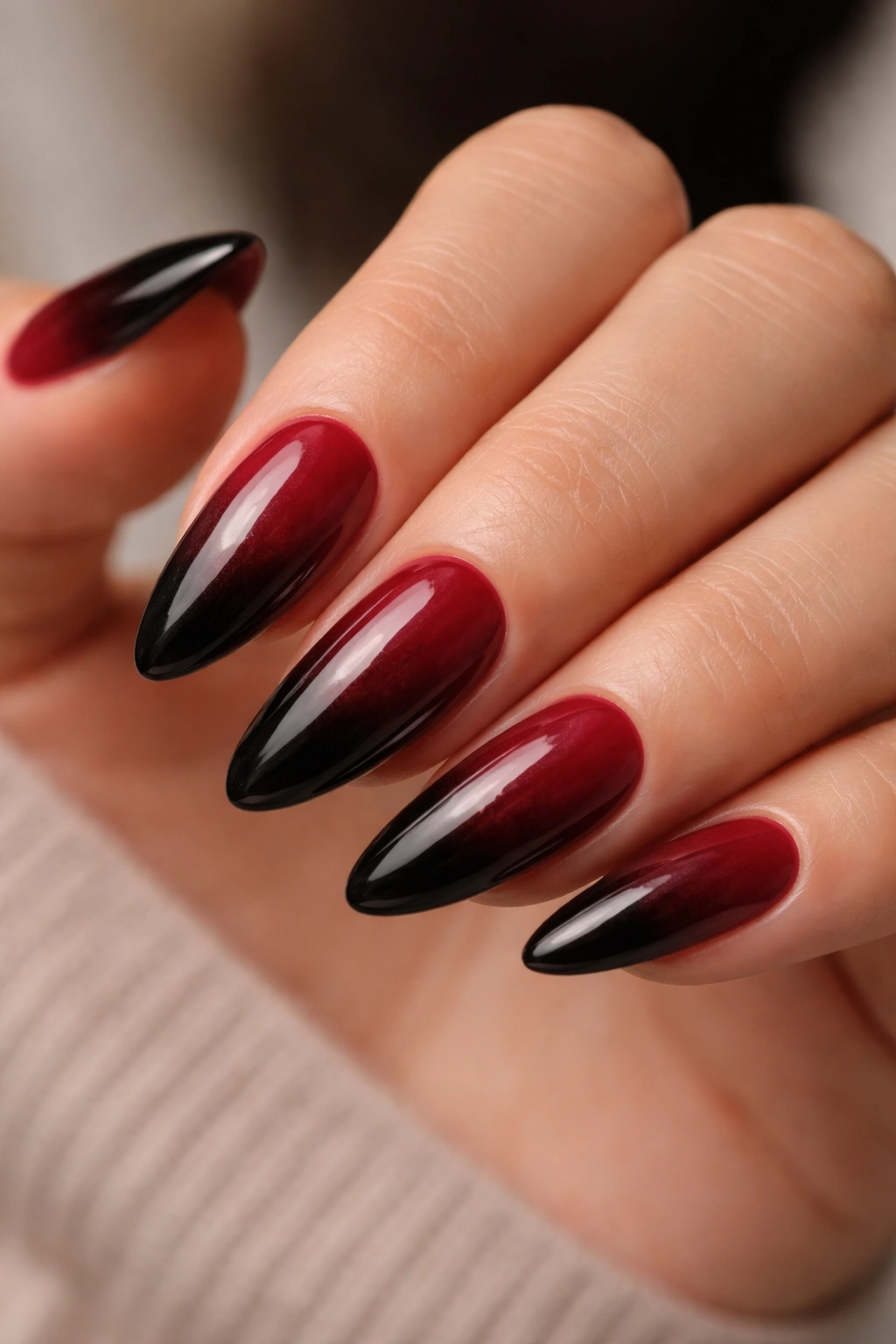 Close-up of almond nails burgundy to black ombre