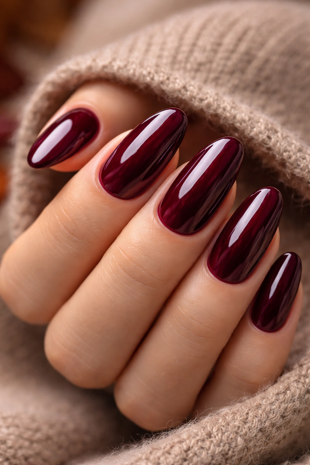 Close-up of nails painted in a deep burgundy wine shade