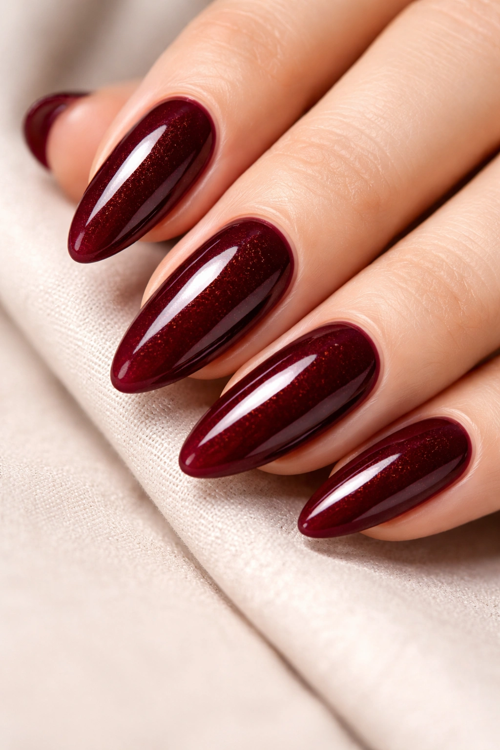 Close-up of burgundy almond nails with glossy finish