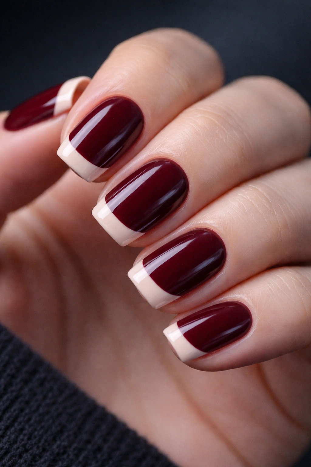 Close-up of deep burgundy nails with nude tip on short squoval nails